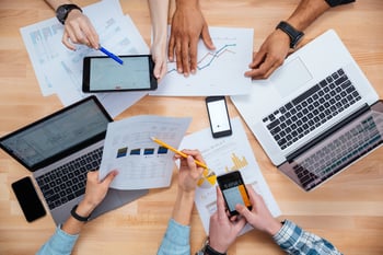 Business people using mobile phones and laptops, calculating and discussing charts and diagrams for financial report